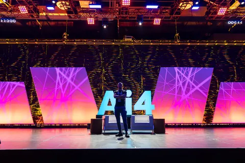 The main AI4 conference stage with lighting and LED screens.