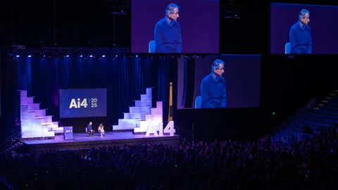 An Ai4 speaker on stage, shown on large screens.