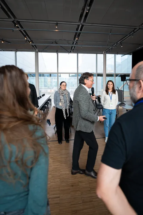 Conference attendees talking in a foyer beside a glass wall.