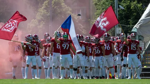 Players entering through smoke with flags.