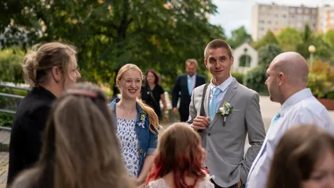 Newlyweds and guests at a garden wedding ceremony.